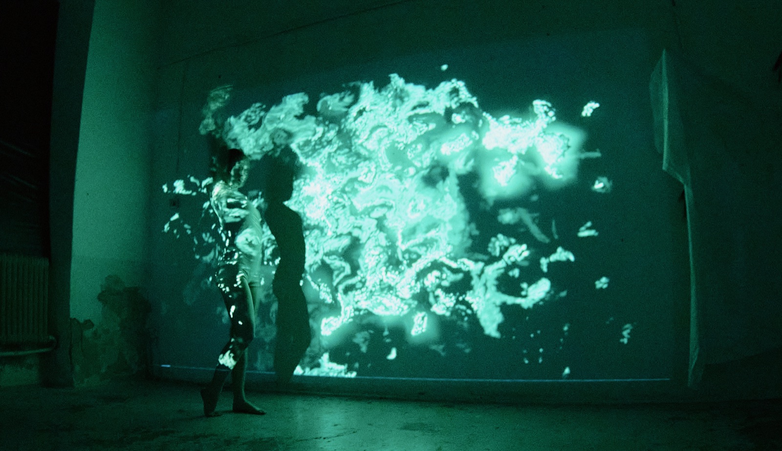 A dancer surrounded by reactive projected visuals